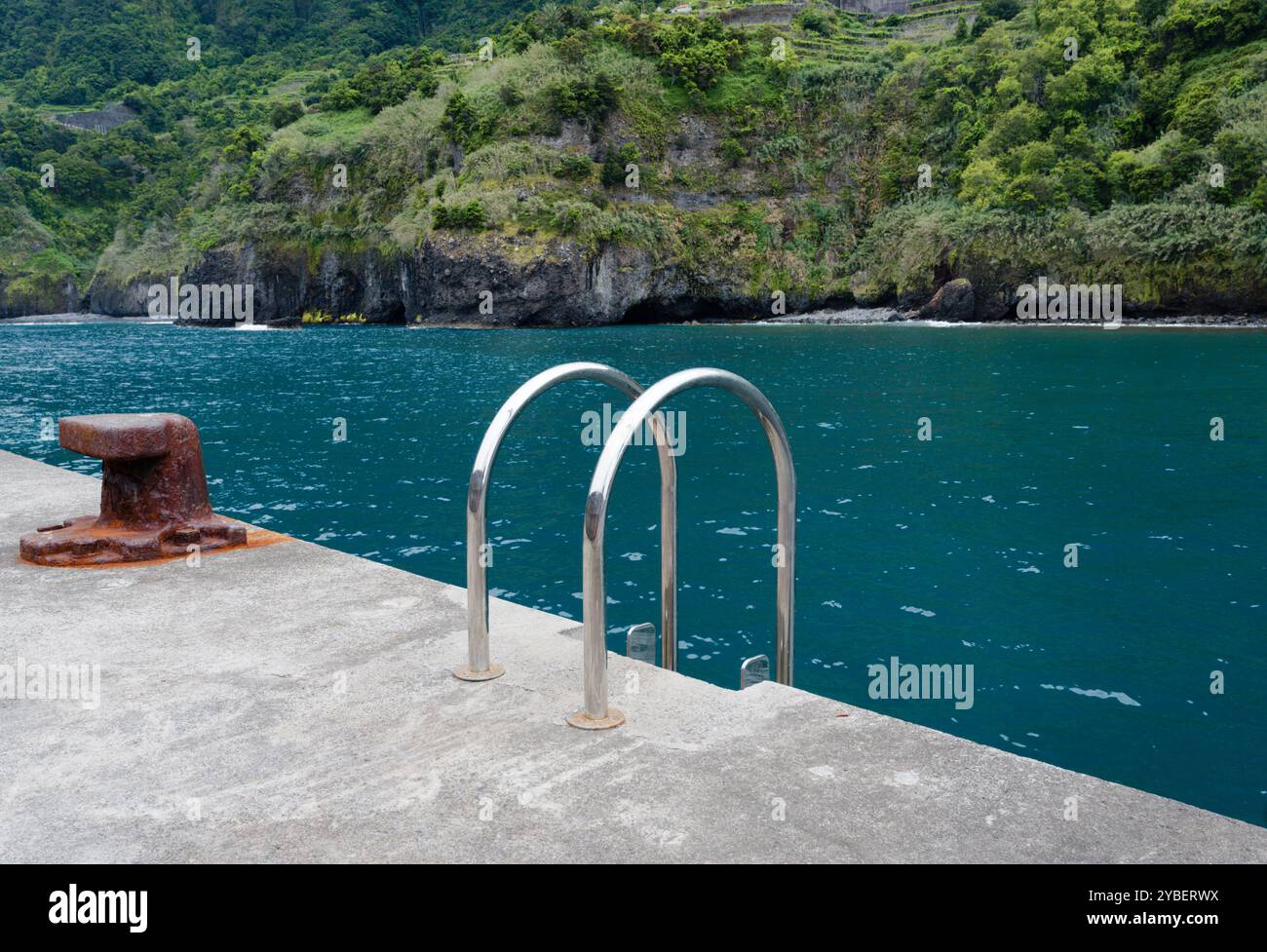 Scala verso il mare con rigogliose scogliere sullo sfondo a Seixal Foto Stock