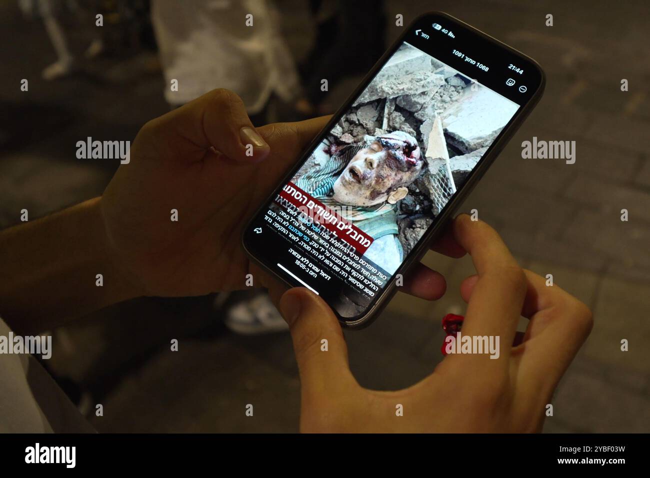 GERUSALEMME - 17 OTTOBRE: Una persona mostra sul suo smartphone una foto che sembra mostrare il corpo del leader di Hamas Yahya Sinwar ucciso mentre gli israeliani celebrano la notizia della morte di Sinwar a Gaza il 17 ottobre 2024 a Gerusalemme. Israele ha confermato la morte del capo di Hamas Yahya Sinwar, la mente dell'attentato del 7 ottobre, definendolo una grande battuta d'arresto per il gruppo palestinese che combatte da più di un anno. Foto Stock