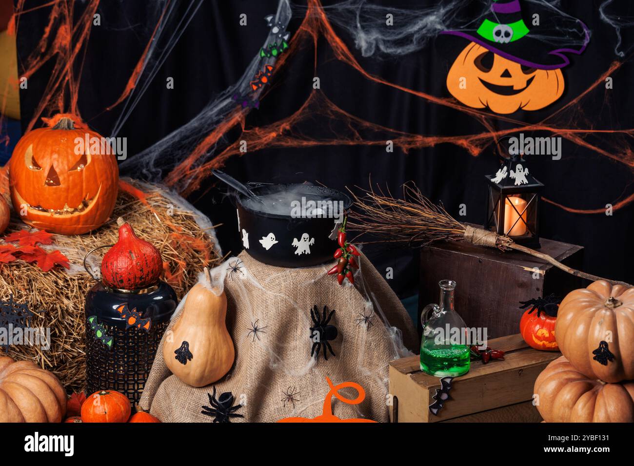 Zucche, fieno, scopa, calderone, fantasmi. Area fotografica per Halloween, decorazioni e oggetti di scena, vacanze autunnali. Foto Stock