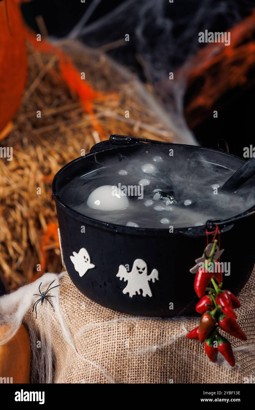 Cauldron, fantasmi, ragni, ragnatele. Area fotografica per Halloween, decorazioni e oggetti di scena, vacanze autunnali. Foto Stock