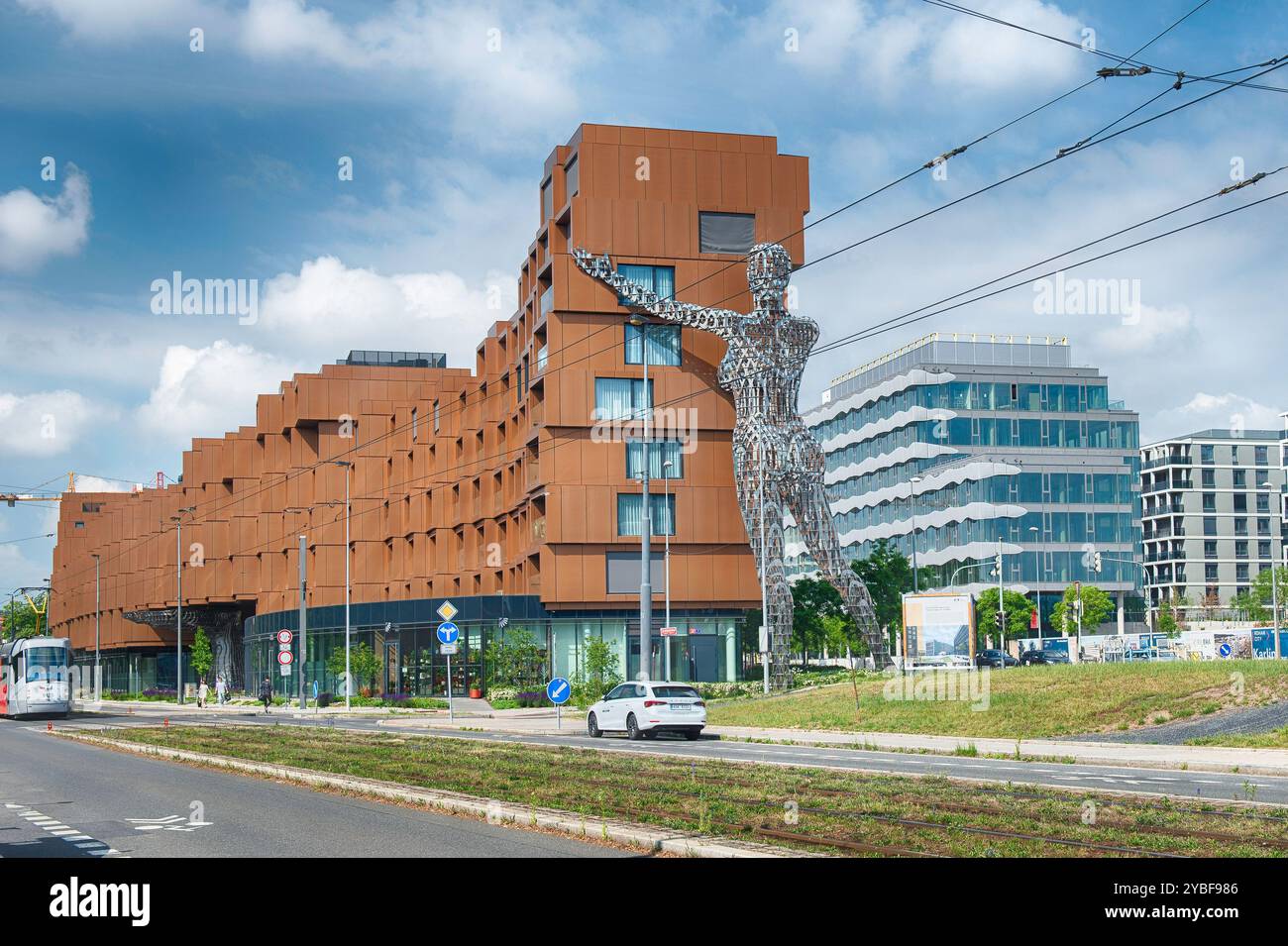 PRAGA - 12 MAGGIO 2024: Gigantesca statua metallica che raggiunge un edificio contemporaneo, realizzato da David Cherny a Praga, Repubblica Ceca, in una soleggiata estate Foto Stock