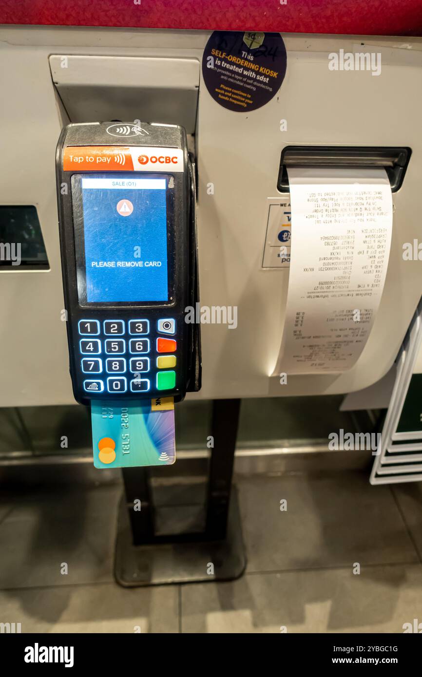 Terminale di carta di debito McDonalds per il pagamento , pagamento di ordini alimentari , terminale di carta, carta inserita, ricevuta, ricevute, Singapore - rimuovere la carta Foto Stock