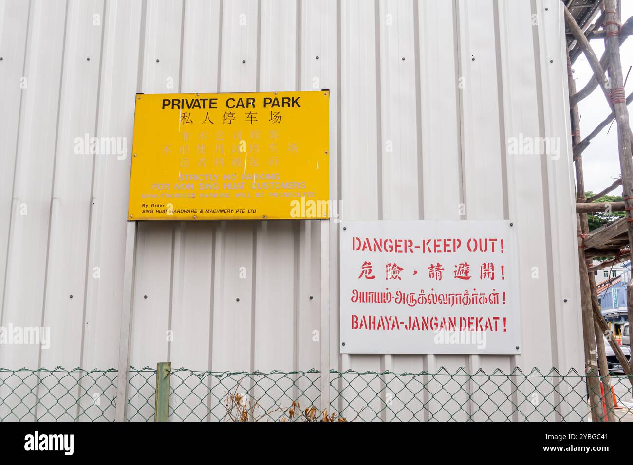 Cartello bilingue del parcheggio privato - cartello "pericolo non perderti" in quattro lingue - malese, cinese, tailandese, inglese, Singapore Foto Stock