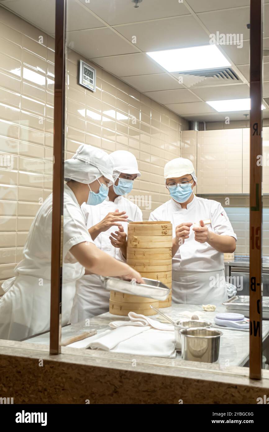 Cuochi che preparano gnocchi al vapore nel ristorante di cucina taiwanese DIN Tai Fung Singapore Foto Stock