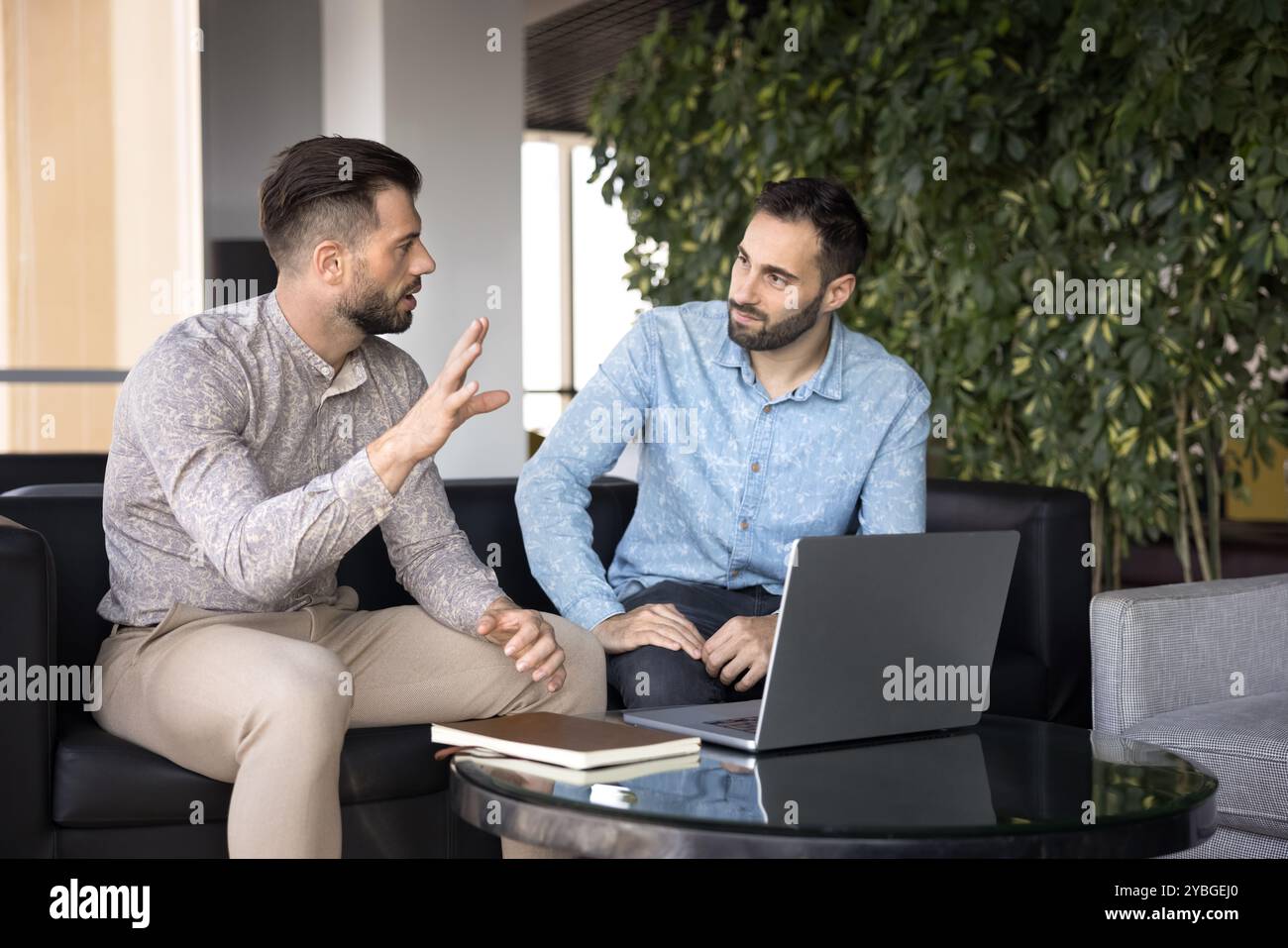 Due partner commerciali che discutono di un progetto di lavoro sul laptop Foto Stock