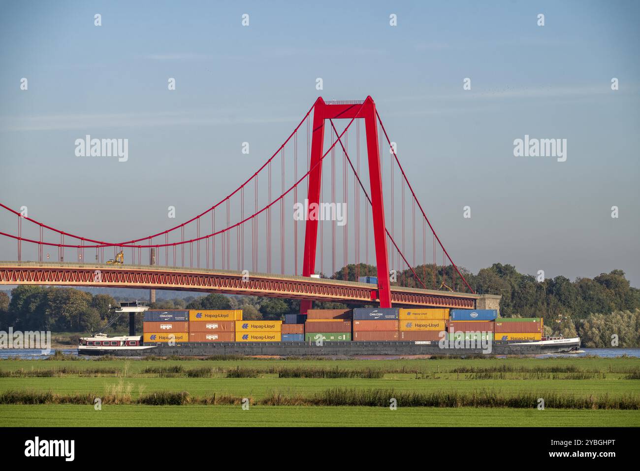 Il ponte Emmerich Rhine, strada federale B220, il ponte sospeso più lungo della Germania, è attualmente in fase di ristrutturazione, danni al ponte, nave cargo per container o Foto Stock