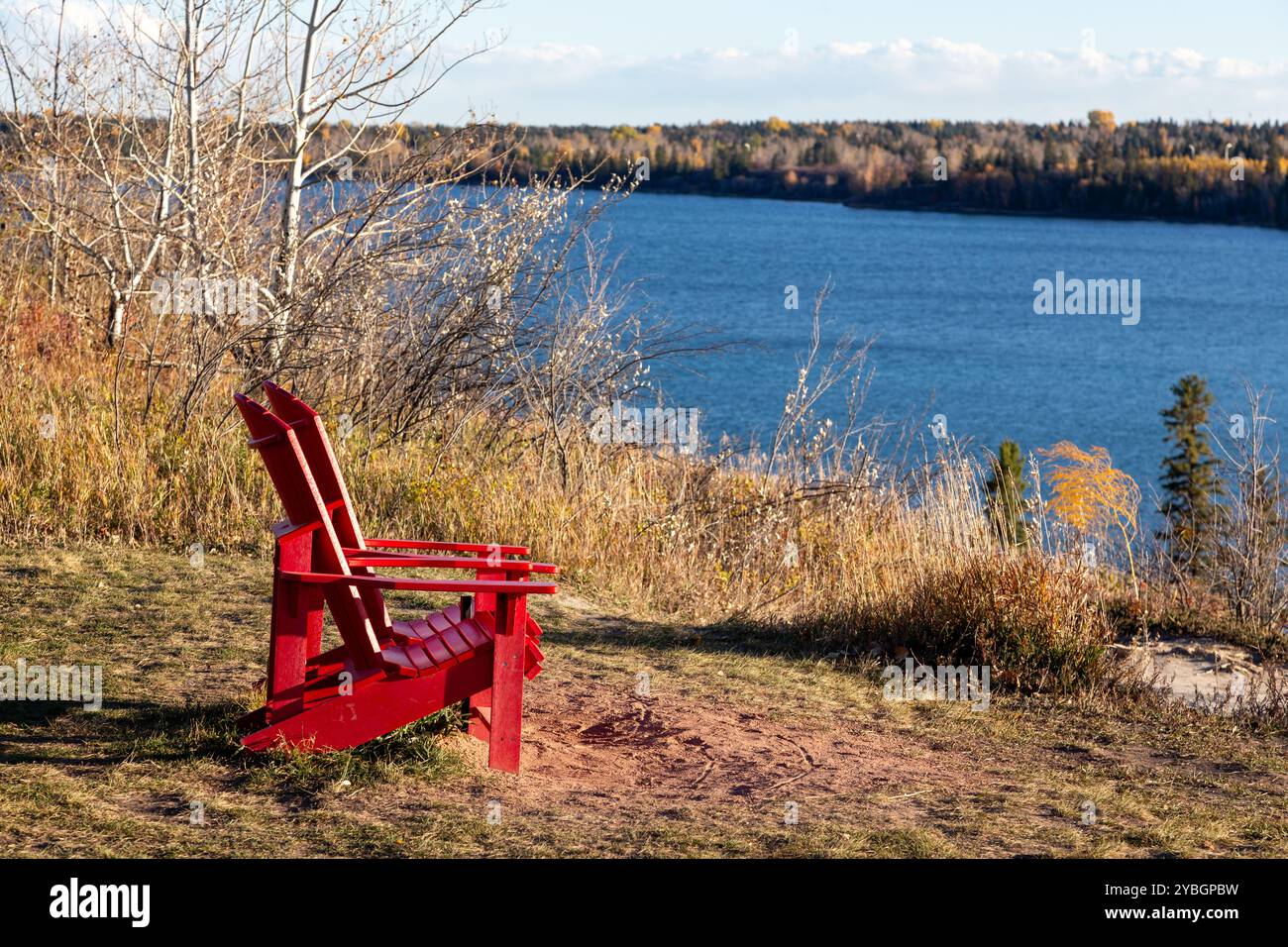Le sedie Red Adirondack abbinano il punto panoramico del lago artificiale North Glenmore. Paesaggio paesaggistico Weaselhead Natural Environment Park, Calgary sud-ovest, Alberta, Canada Foto Stock