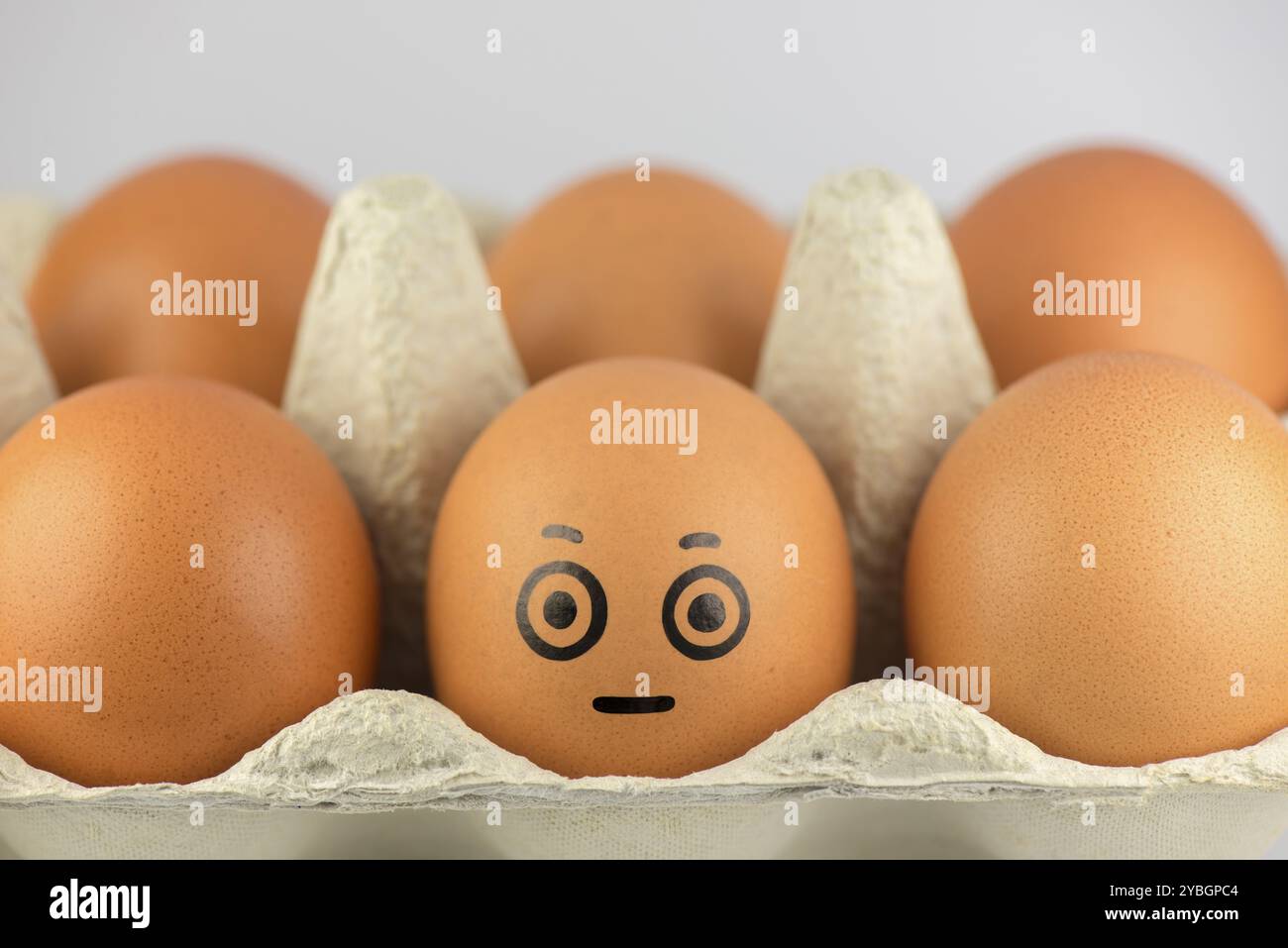 Uovo con una faccia in una confezione di uova Foto Stock