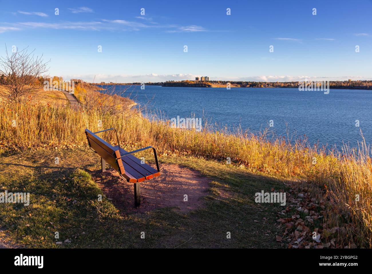 Punto di osservazione del lago artificiale Lonely Park Bench Glenmore. Paesaggio panoramico del parco naturale Weaselhead Calgary Alberta Canada Blue City Skyline Foto Stock