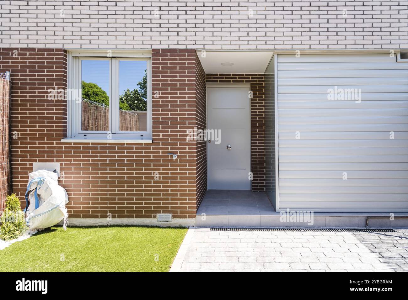 Vista esterna del moderno semi-detached case a schiera con facciata in mattoni. Giornata di sole Foto Stock