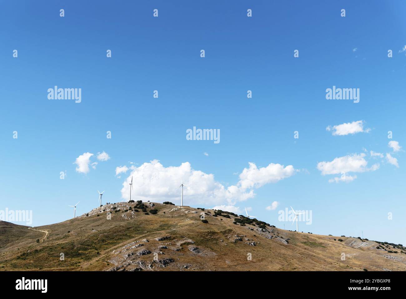 Le turbine eoliche che generano elettricità sulla sommità di una collina contro sky con spazio per la copia. Rinnovabile, sostenibile ed energie alternative Foto Stock