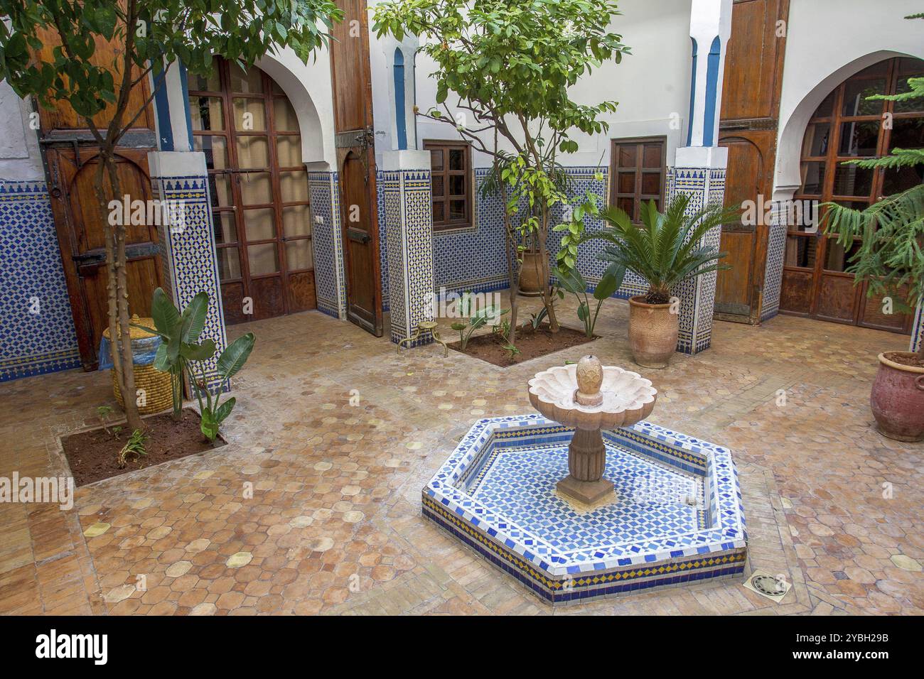 Interni in un tipico hotel di Marrakech con famose (non esclusive) piastrelle marocchine su pareti e pavimenti e piante in vaso Foto Stock