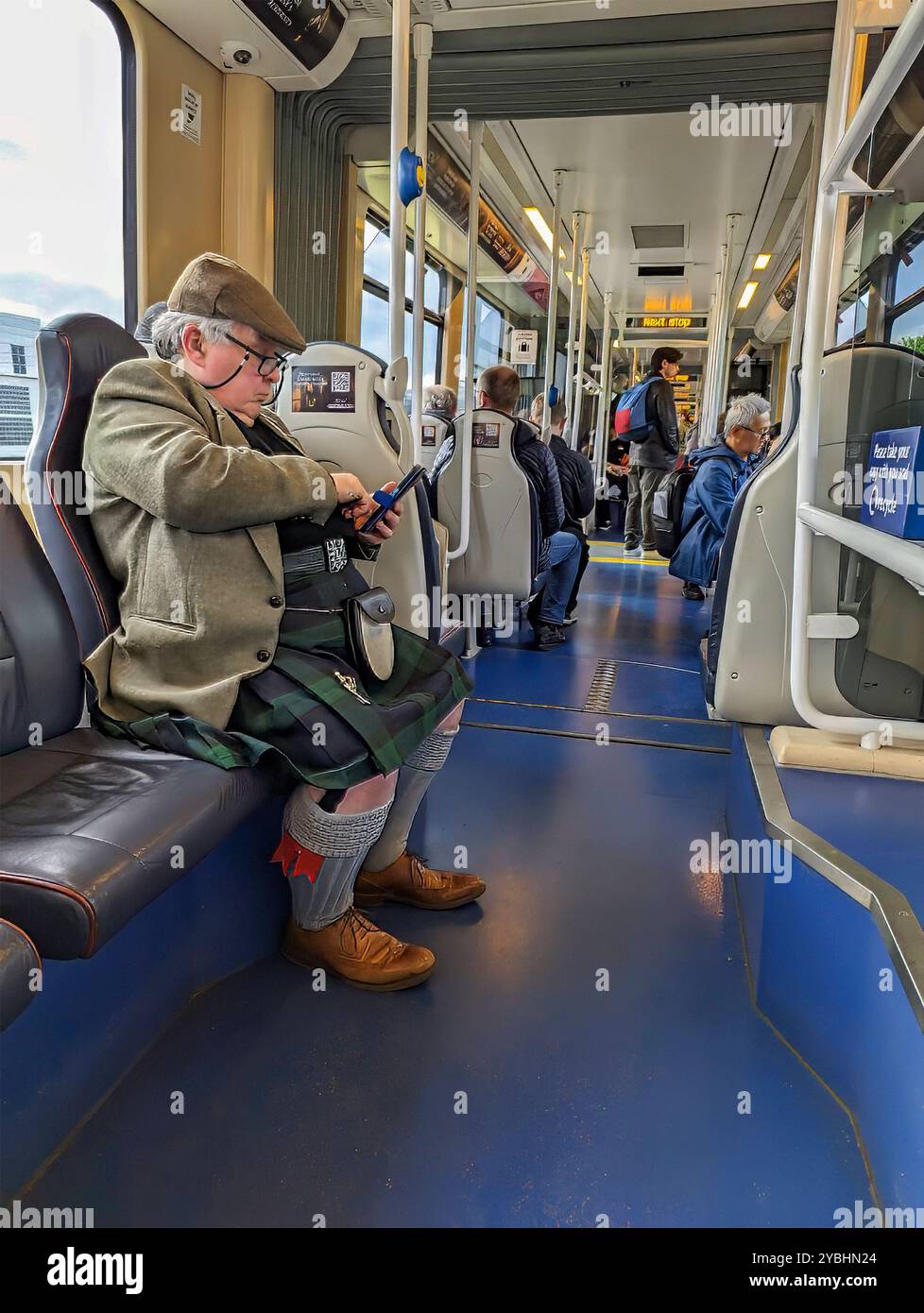 Edimburgo, Scozia, 10 maggio 2024: Uno scozzese, vestito con uniformi tradizionali di kilt e sporrans, si sposta in un tram a Princess Street. Foto Stock