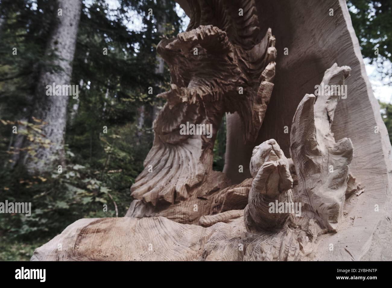 Paura ed inevitabilità: Scultura all'aperto di alberi raffigurante un uccello di preda che caccia un piccolo roditore, in fuga nel terrore. Foto Stock