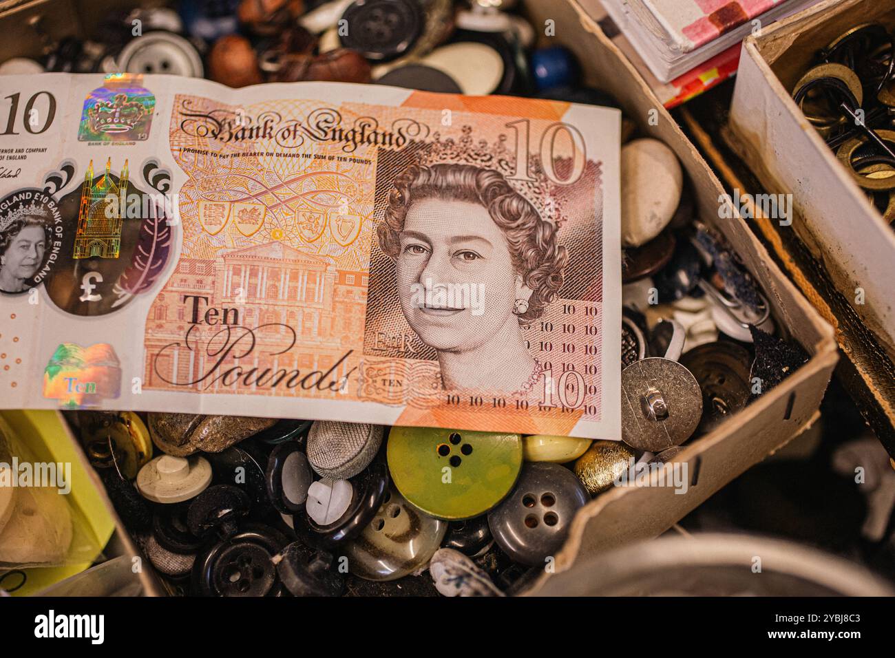 Pagamento in contanti di una banconota da dieci sterline inglesi in negozio Foto Stock