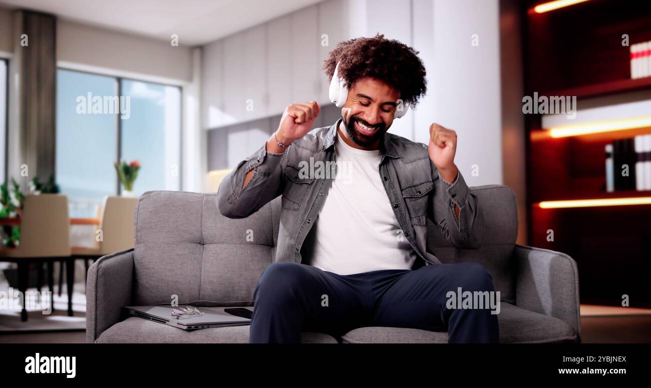 Uomo afroamericano sorridente che ascolta musica sulle cuffie Foto Stock