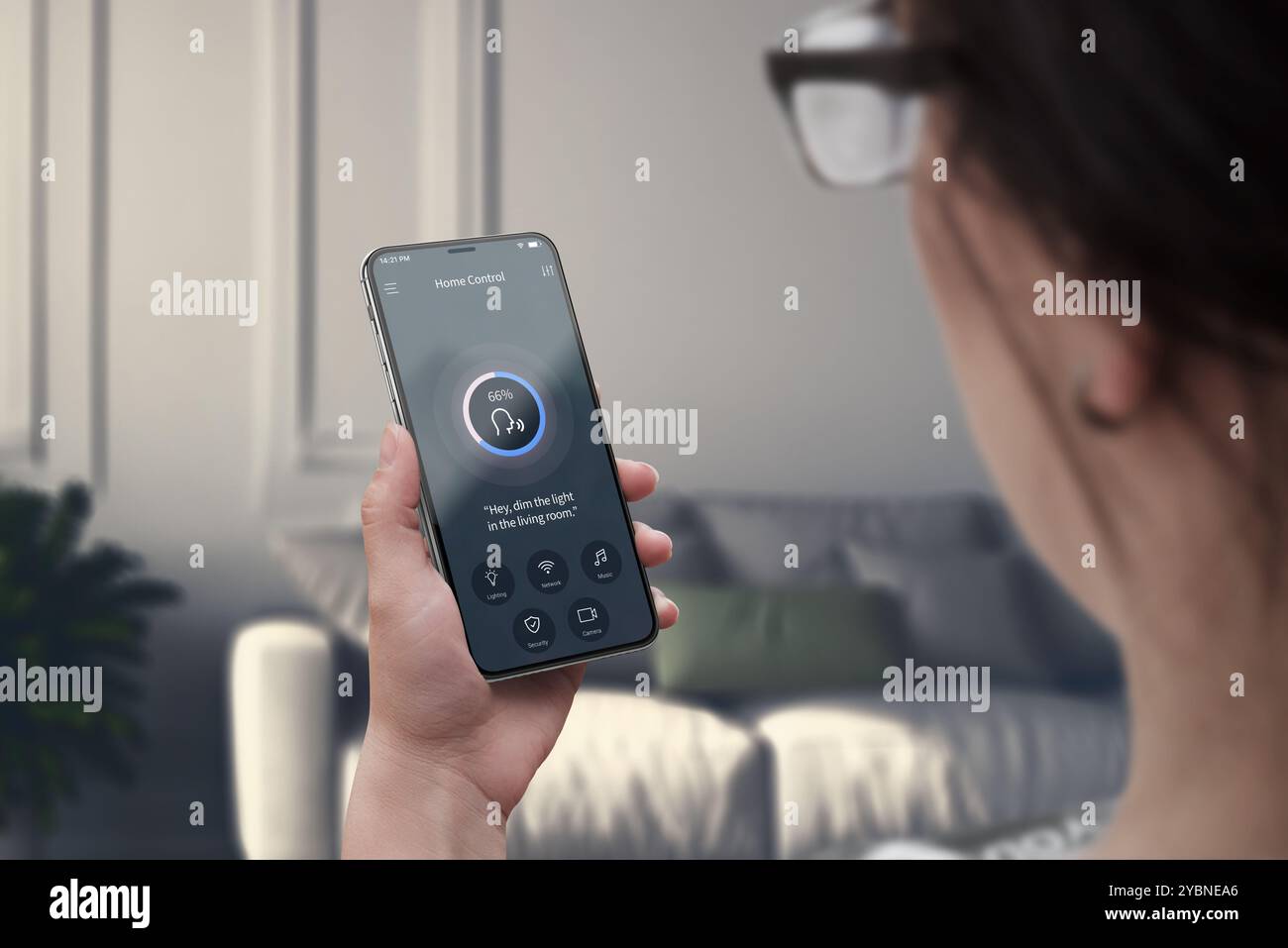 Gestione dell'illuminazione a comando vocale in una casa moderna. La donna usa il telefono per regolare l'atmosfera in modo semplice in salotto Foto Stock