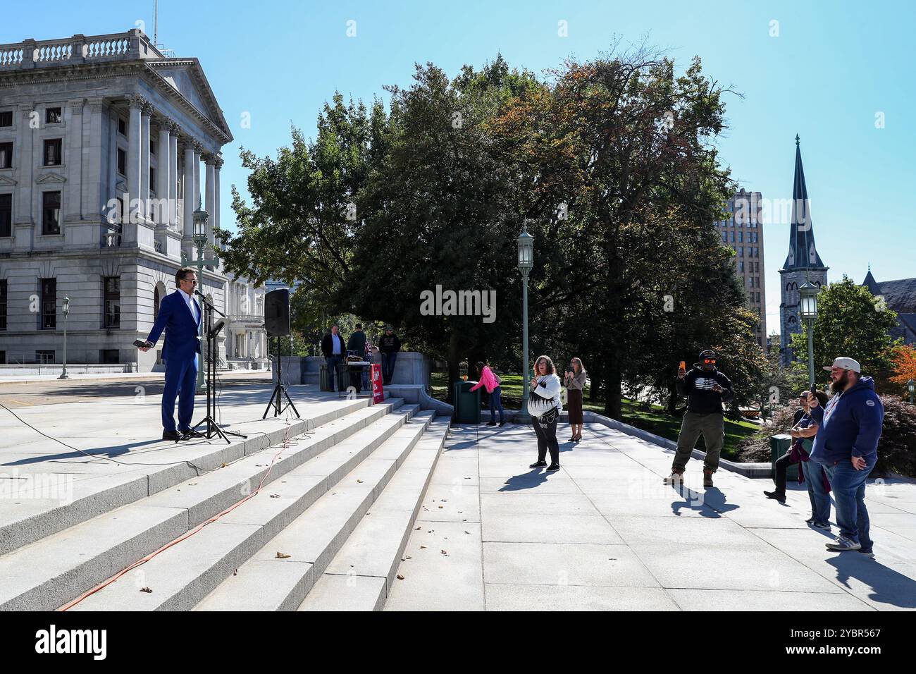 Harrisburg, Stati Uniti. 19 ottobre 2024. John Bolaris (l), agente immobiliare di Filadelfia ed ex meteorologo televisivo, parla con un gruppo di circa una dozzina di sostenitori di Trump riuniti sui gradini del Campidoglio della Pennsylvania per il rally Trump Train Rise for Liberty ad Harrisburg sabato 19 ottobre 2024. (Foto di Paul Weaver/Sipa USA) credito: SIPA USA/Alamy Live News Foto Stock