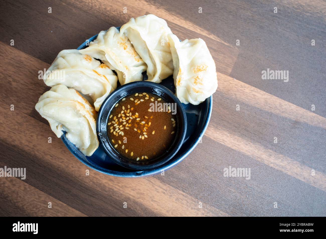 Gyoza giapponese tradizionale con carne e salsa di soia su un tavolo di legno. Foto Stock