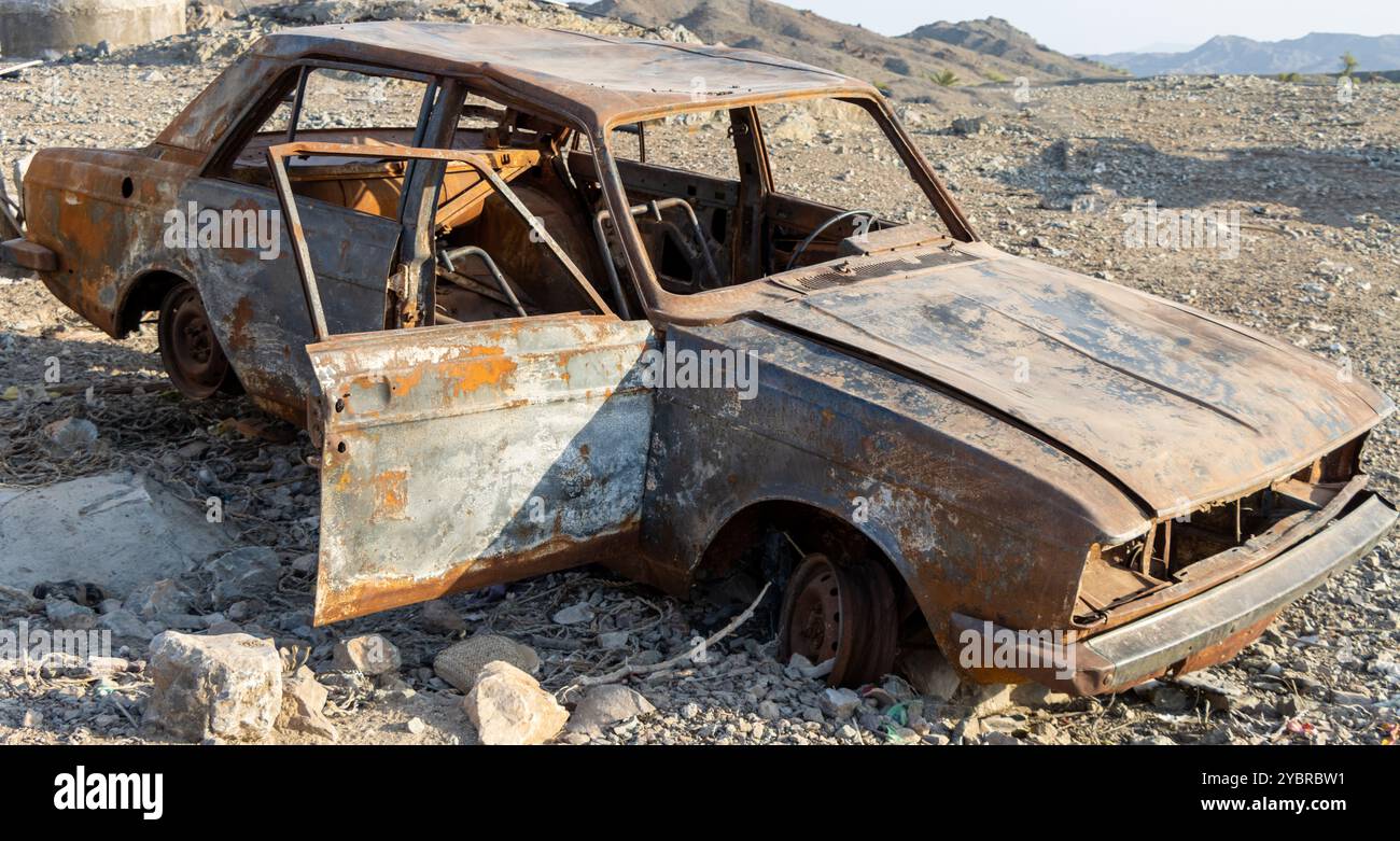 Vecchia macchina spazzatura bruciata e arrugginita Foto Stock