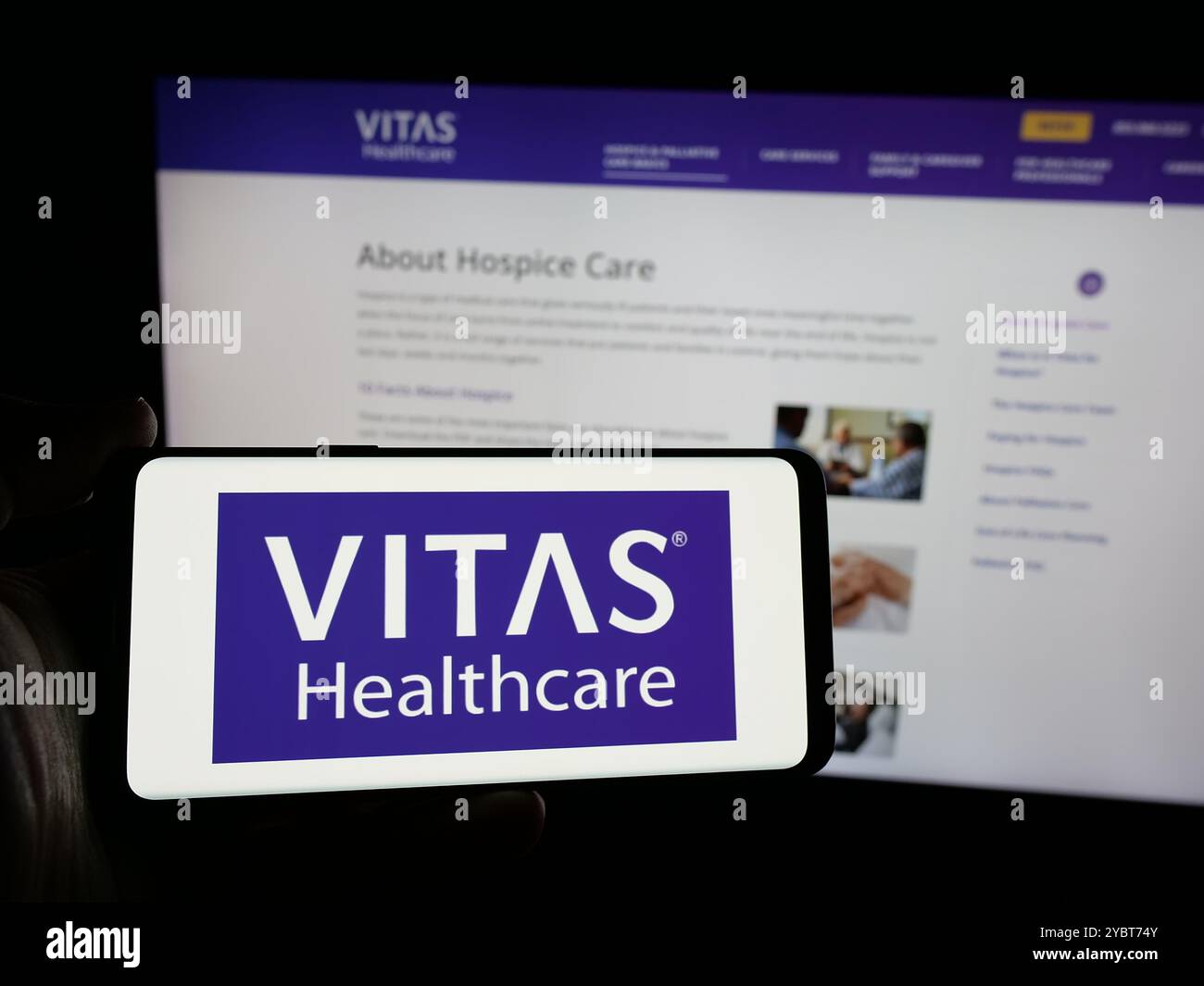 Persona che tiene lo smartphone con il logo della società sanitaria statunitense VITAS Healthcare sullo schermo di fronte al sito web. Mettere a fuoco il display del telefono. Foto Stock