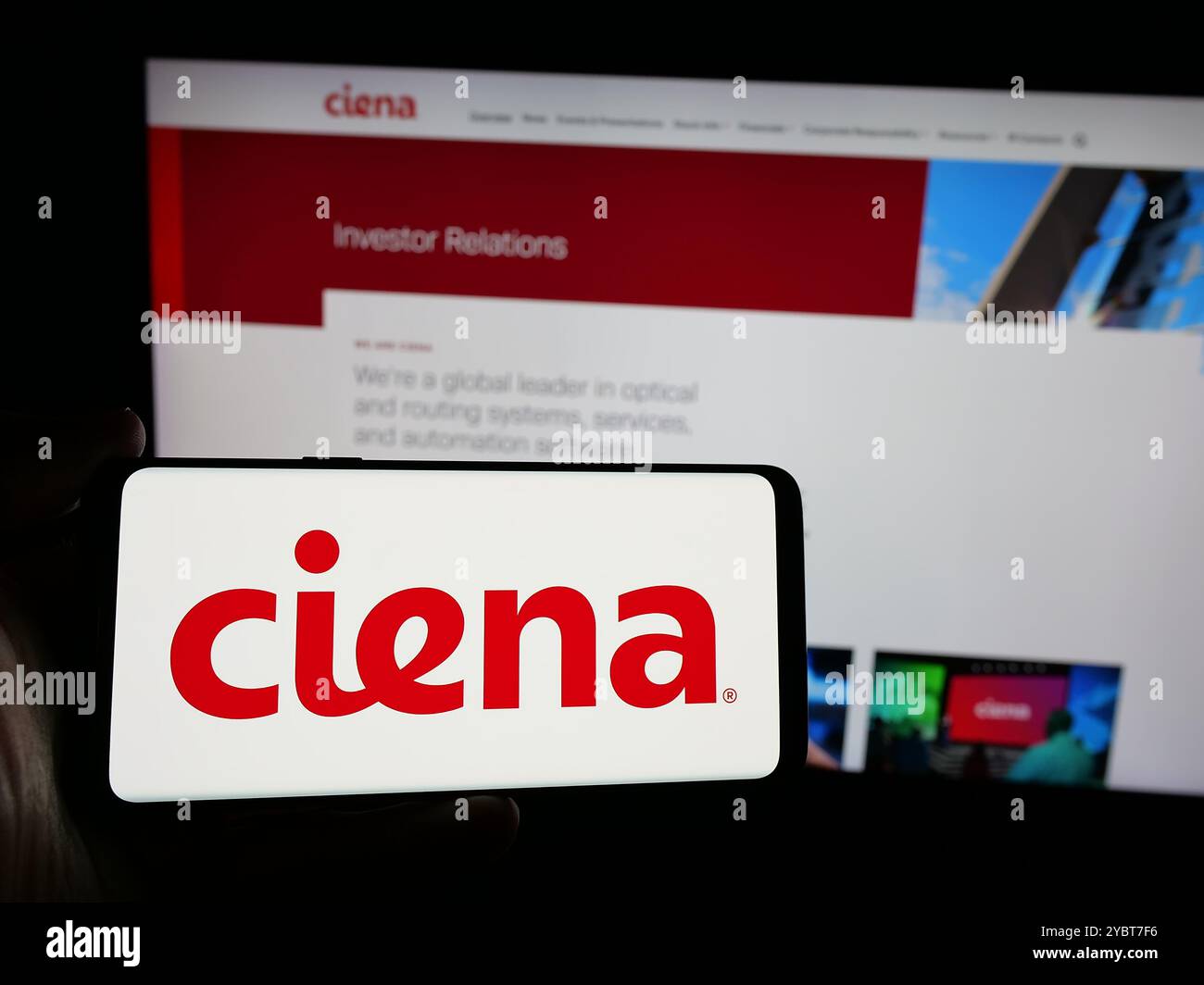 Persona che possiede uno smartphone con il logo della società statunitense di sistemi di rete Ciena Corporation sullo schermo di fronte al sito Web. Mettere a fuoco il display del telefono. Foto Stock