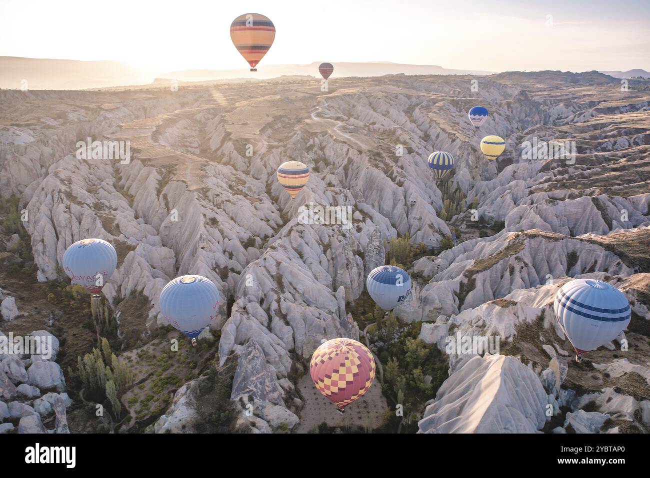 Diverse mongolfiere volano su un paesaggio roccioso alla luce del mattino, Goereme, Turchia, Asia Foto Stock