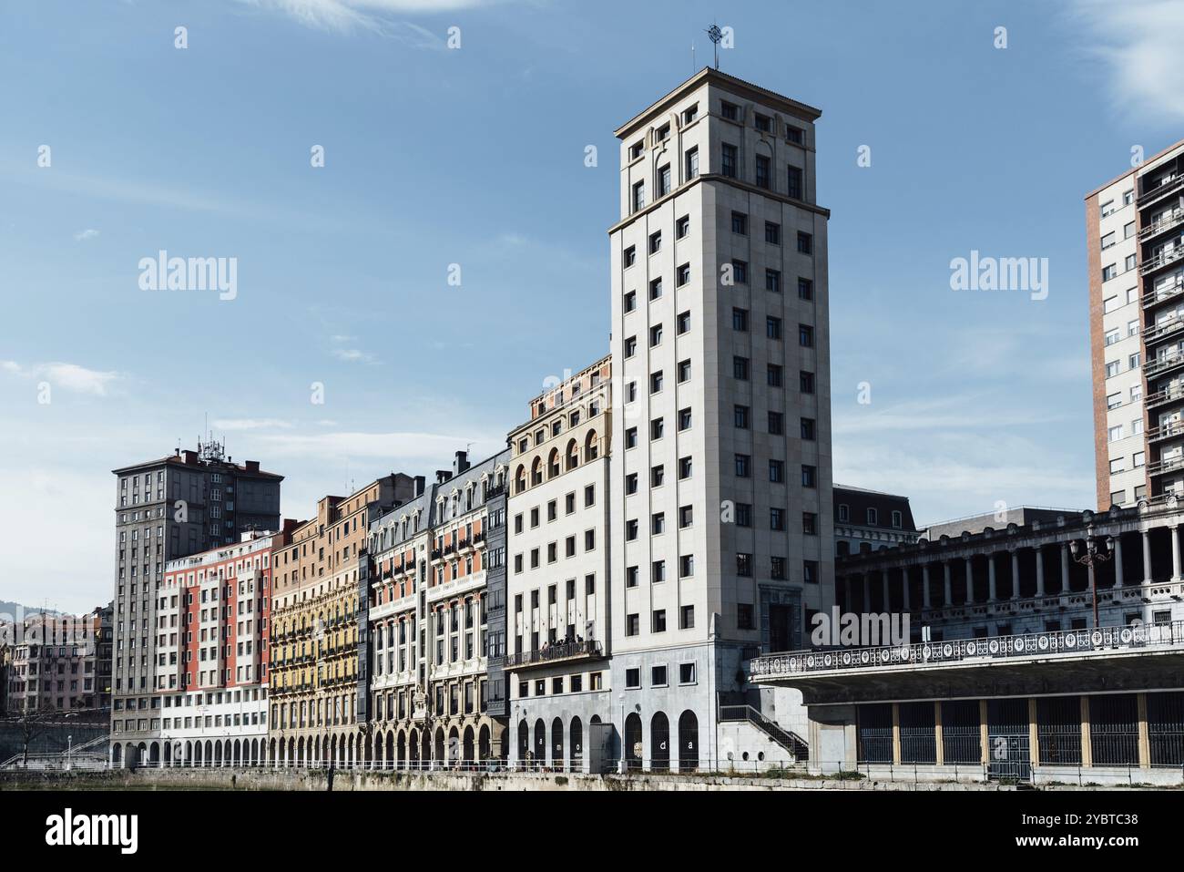 Bilbao, Spagna, 13 febbraio 2022: Edifici residenziali tradizionali e grattacielo di Bailen sul lungofiume del fiume Nervion nel quartiere vecchio di B. Foto Stock
