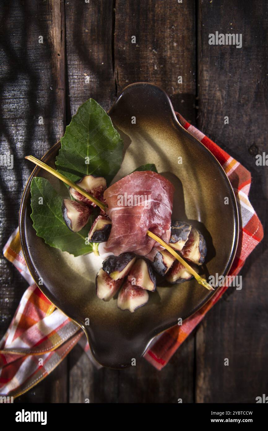 Presentazione su spiedino piatto con fichi e prosciutto Foto Stock