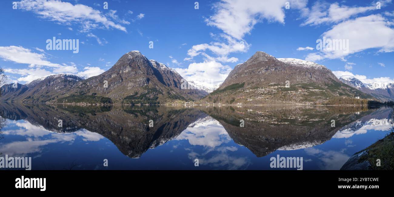 Vista panoramica delle cime montane che si riflettono nel lago Sandvevatnet vicino al villaggio norvegese Odda in provincia di Hordaland Foto Stock