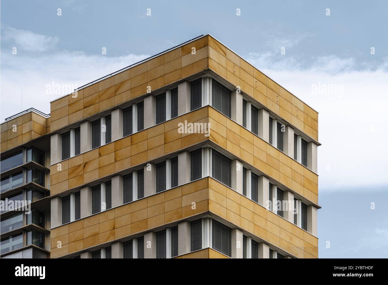 Berlino, Germania, 28 luglio 2019: Edificio di uffici dall'architettura moderna con facciata ventilata in pietra. Vista ad angolo basso contro il cielo, Europa Foto Stock