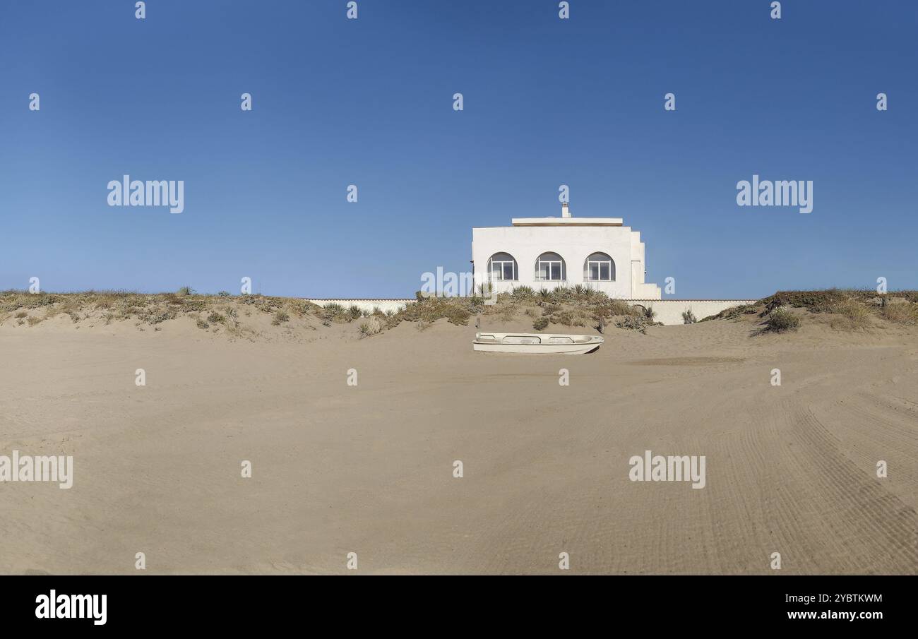 Casa sul mare con barca in primo piano al tramonto. Località. Solitudine Foto Stock