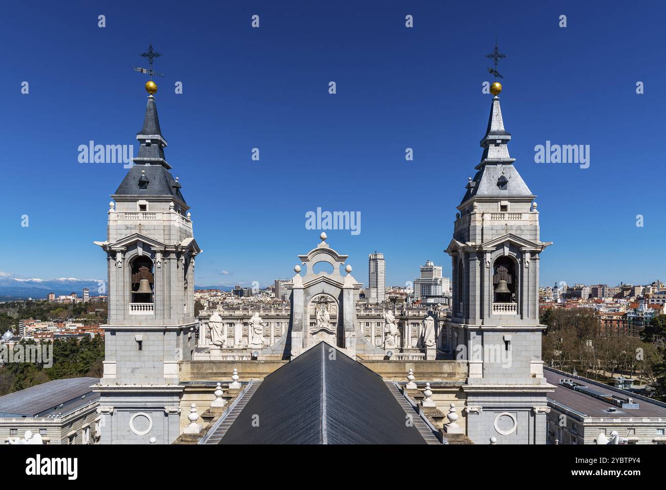 Madrid, Spagna, 20 marzo 2021: Il tetto e i campanili della Cattedrale di Almudena contro il paesaggio urbano di Madrid. Giornata di sole con cielo azzurro, Europa Foto Stock