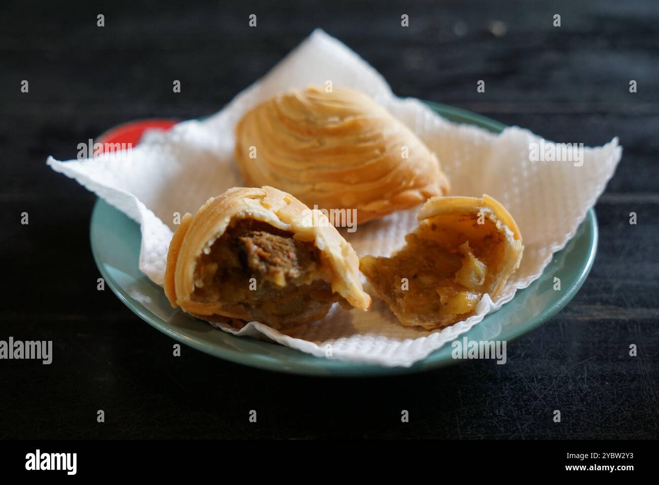Un piatto di sfoglia malese fritta al curry o epok-epok isolato su sfondo scuro. Noto anche come Karipap Pusing. Foto Stock