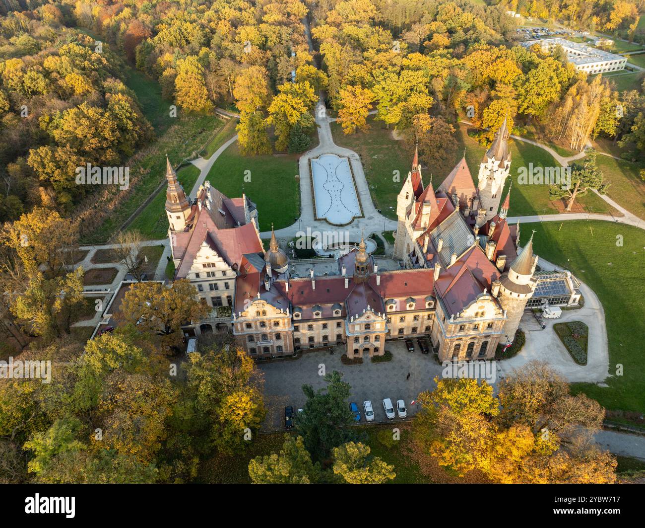 Riprese aeree del drone del castello di Moszna, Polonia, viste mozzafiato della maestosa architettura neogotica e barocca, circondate da lussureggianti giardini e panorami Foto Stock