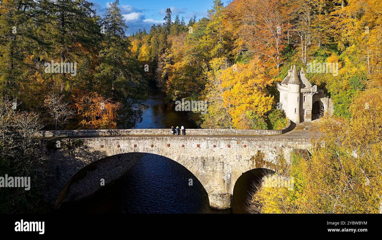 Ponte di Avon ponte sul fiume Avon a Ballindalloch Moray Scozia e persone che ammirano gli alberi dai vivaci colori autunnali Foto Stock