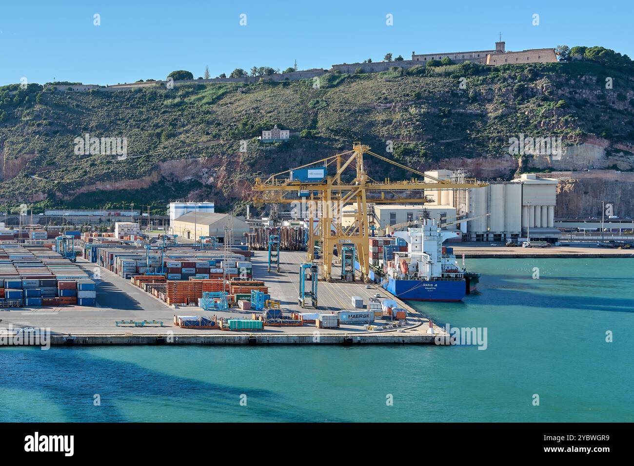 Barcellona. Espain -20 ottobre 2024: Vista del porto di Barcellona con una nave da carico attraccata e gru che scaricano container. Rappresenta l'attività della porta e. Foto Stock