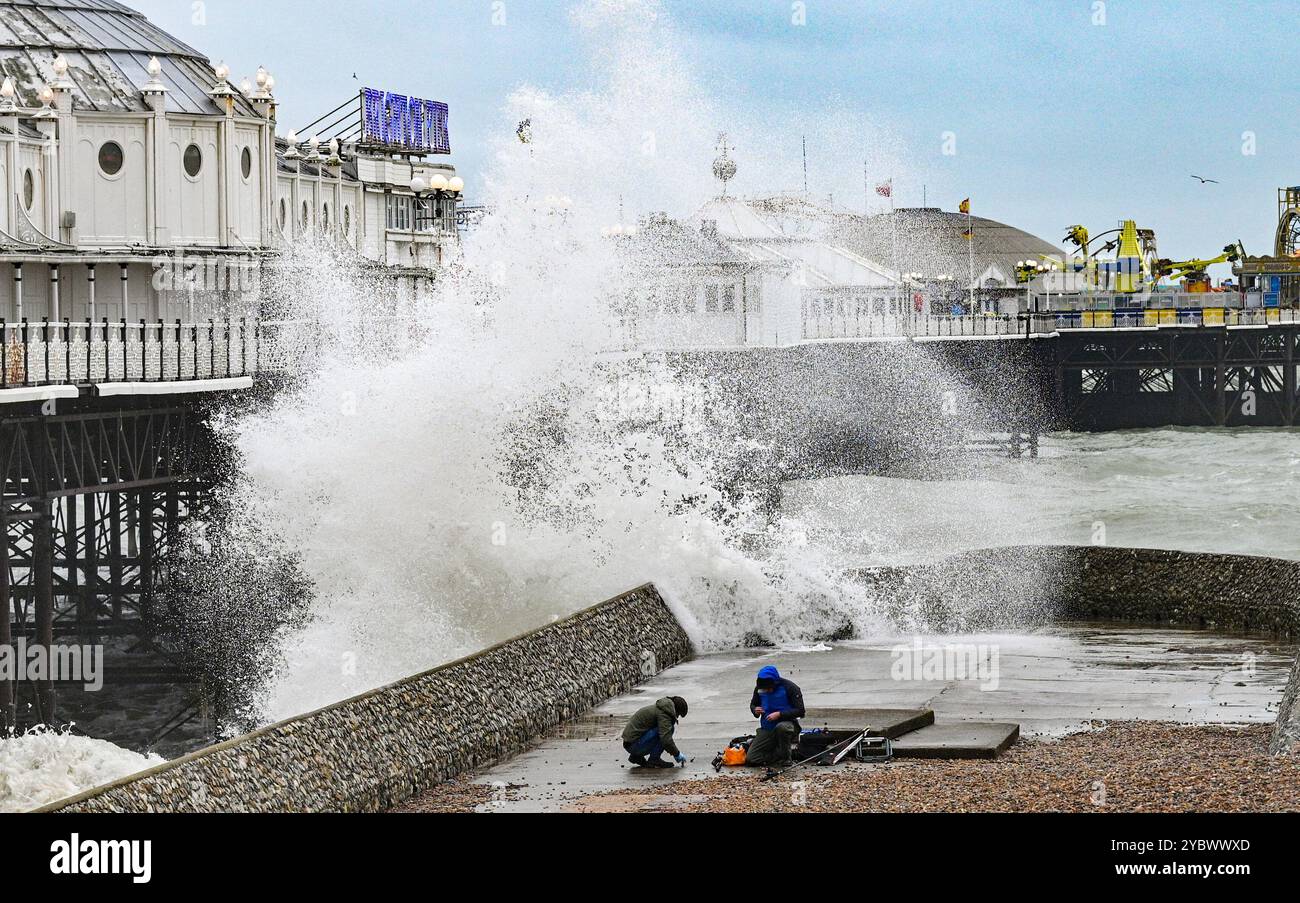 Brighton Regno Unito 20 ottobre 2024 - i pescatori di mare che pescano presso il molo di Brighton Palace vengono catturati dalle grandi onde che si infrangono come Storm Ashley batters parti della Gran Bretagna oggi . È stato emesso un avviso meteo ambra per alcune parti del Regno Unito con previsioni di vento che raggiungono i 80 km/h: Credit Simon Dack / Alamy Live News Foto Stock