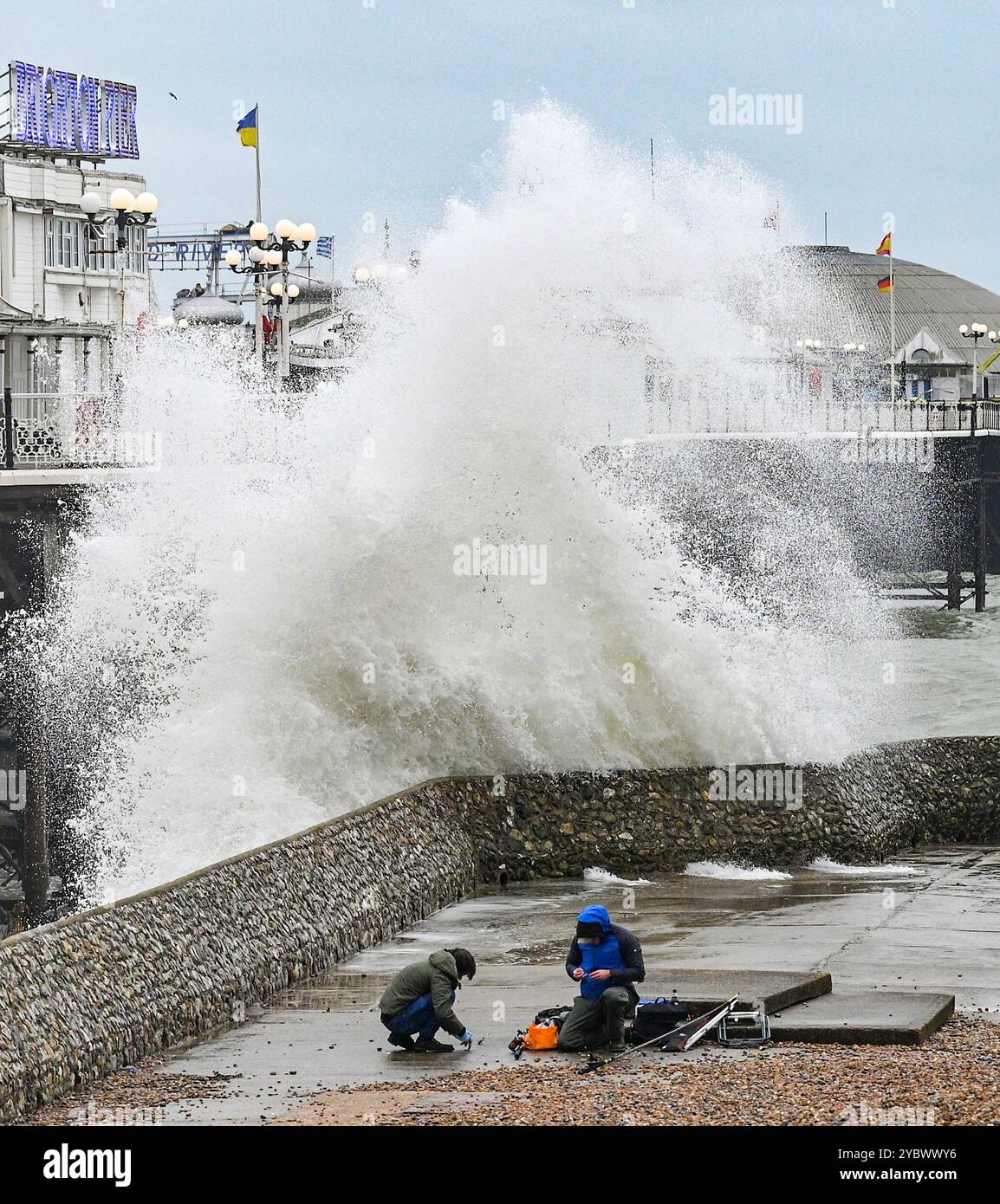 Brighton Regno Unito 20 ottobre 2024 - i pescatori di mare che pescano presso il molo di Brighton Palace vengono catturati dalle grandi onde che si infrangono come Storm Ashley batters parti della Gran Bretagna oggi . È stato emesso un avviso meteo ambra per alcune parti del Regno Unito con previsioni di vento che raggiungono i 80 km/h: Credit Simon Dack / Alamy Live News Foto Stock