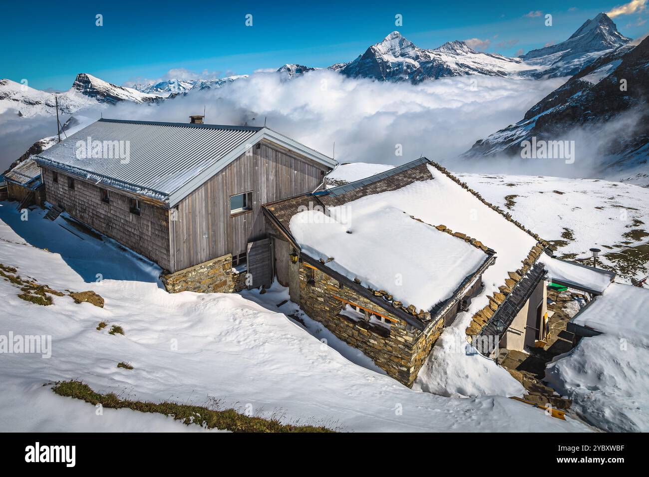 Splendida vista con alte montagne innevate e grazioso rifugio in legno, Grindelwald, Oberland Bernese, Svizzera, Europa Foto Stock