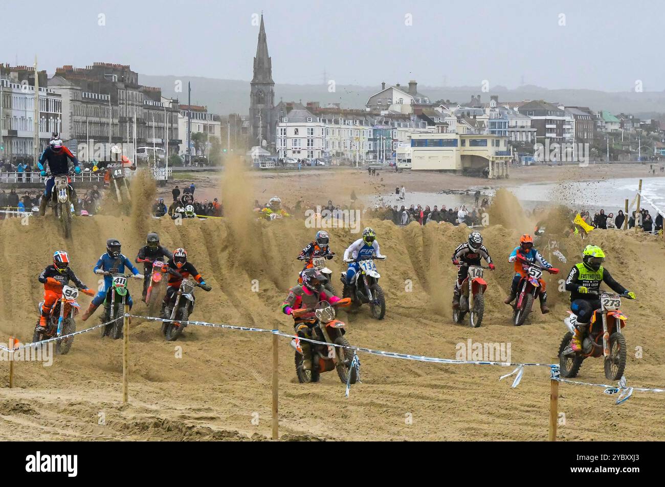 Weymouth, Dorset, Regno Unito. 20 ottobre 2024. Oltre trecento piloti osservati da migliaia di spettatori partecipano alla 40a gara di motocross di Weymouth Beach su un percorso improvvisato scavato dalla sabbia dorata del resort da scavatori. L'evento gratuito annuale è gestito dal Purbeck Motocross Club. Crediti fotografici: Graham Hunt/Alamy Live News Foto Stock