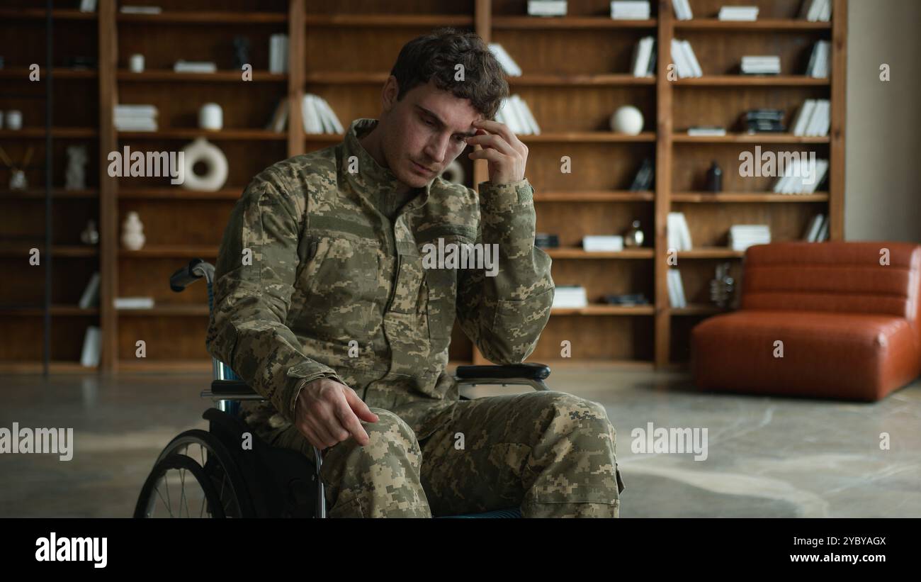 Triste ansioso ufficiale caucasico uomo uniforme da combattimento con disabilità militare militare militare soldato Guy veterano in sedia a rotelle toccando mento viso pensiero Foto Stock