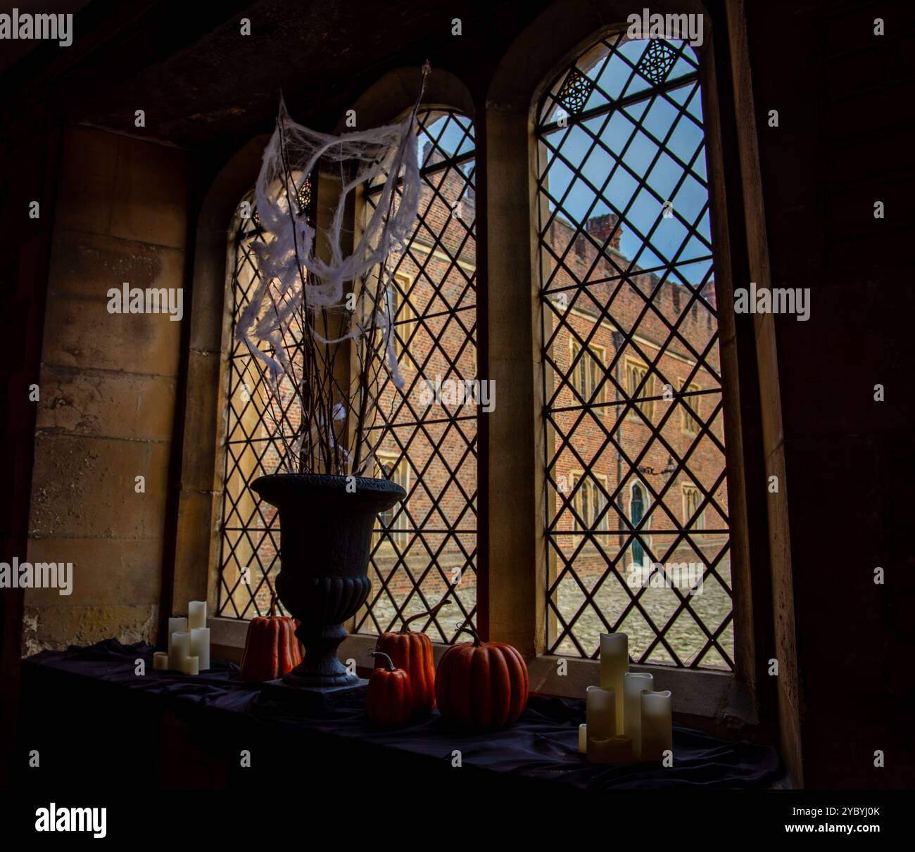 Finestra in stile gotico con decorazioni di Halloween, tra cui zucche, candele e ragnatele, creando un'atmosfera spettrale Foto Stock