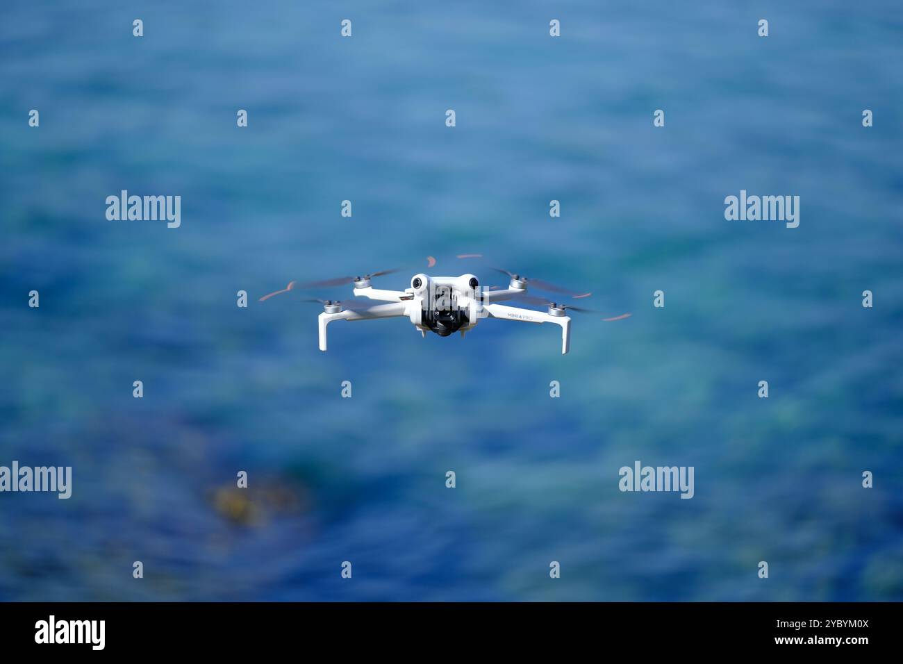 Mini drone che vola sul mare in una giornata estiva di sole, DJI mini pro 4 Foto Stock