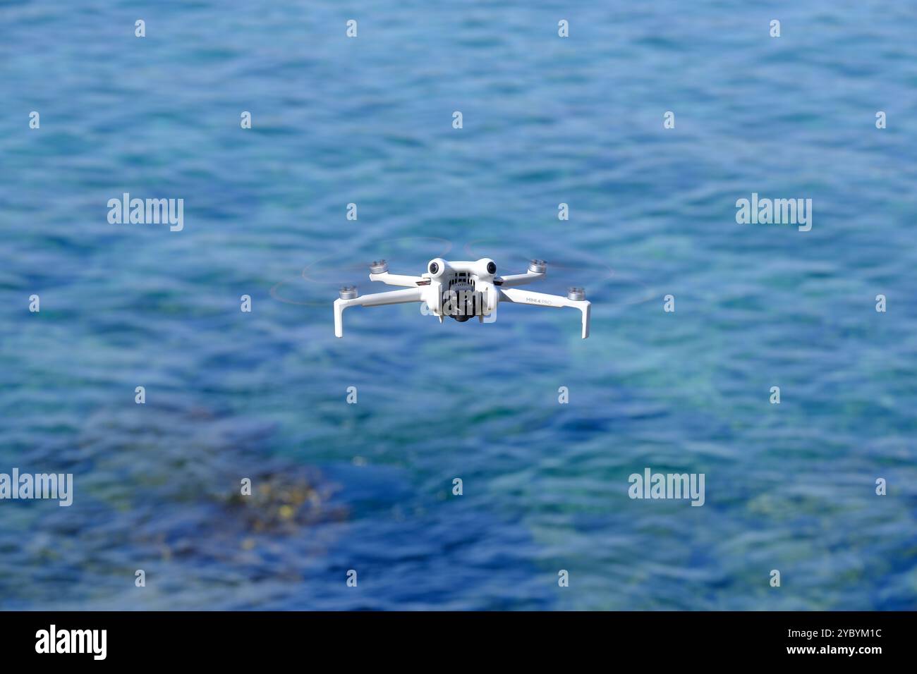 Mini drone che vola sul mare in una giornata estiva di sole, DJI mini pro 4 Foto Stock