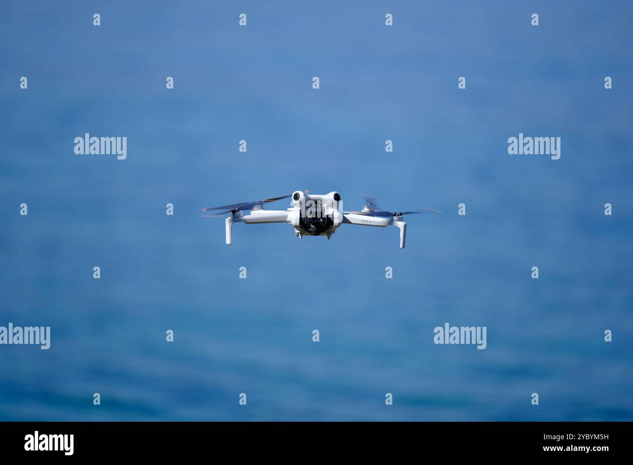 Mini drone che vola sul mare in una giornata estiva di sole, DJI mini pro 4 Foto Stock