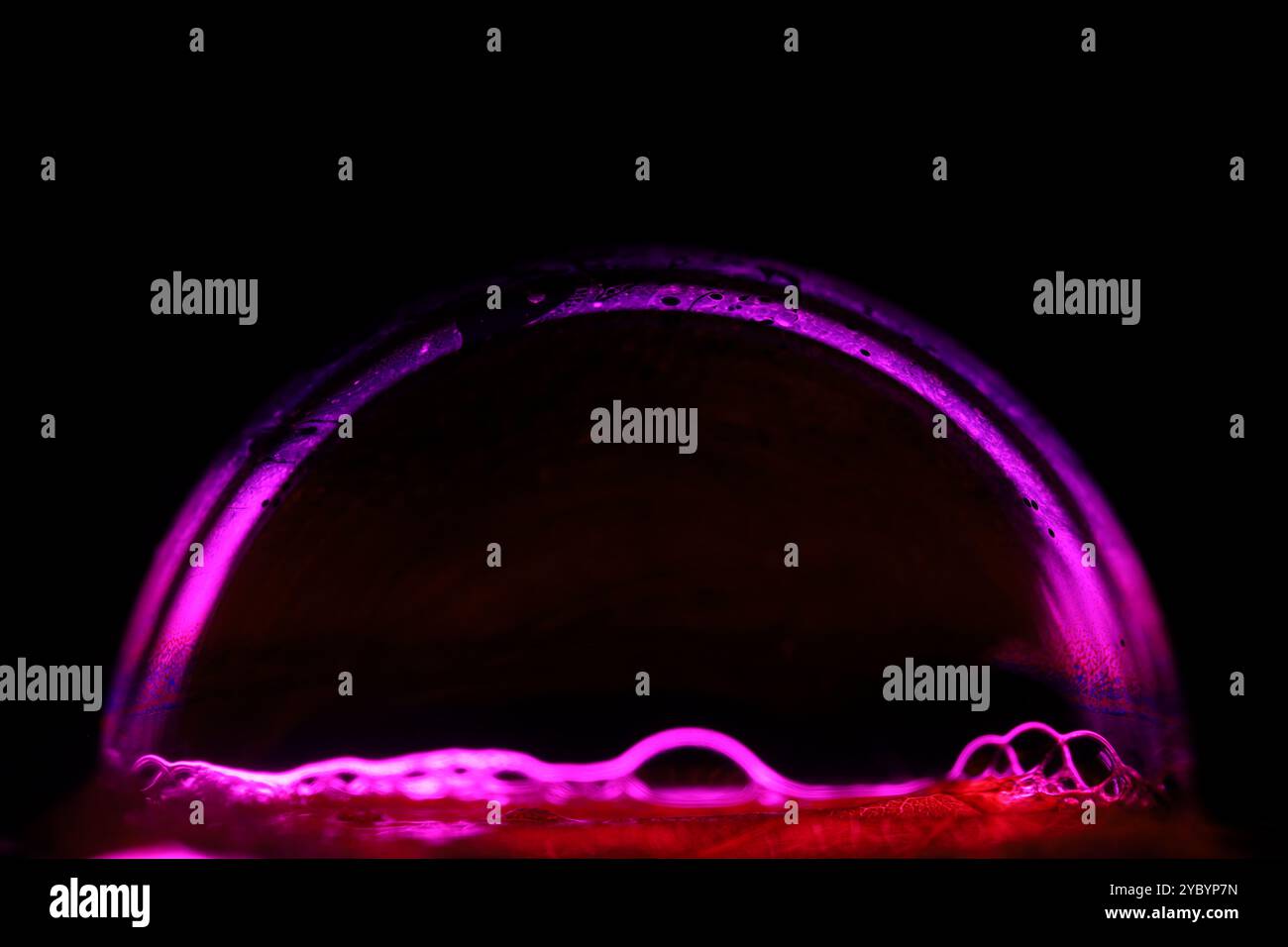 Linea di liquido rosa su sfondo scuro, sfera luminosa, fantastico sfondo liquido, arte minimalista scura, rosa su nero, spazio di copia, sfondo verticale Foto Stock