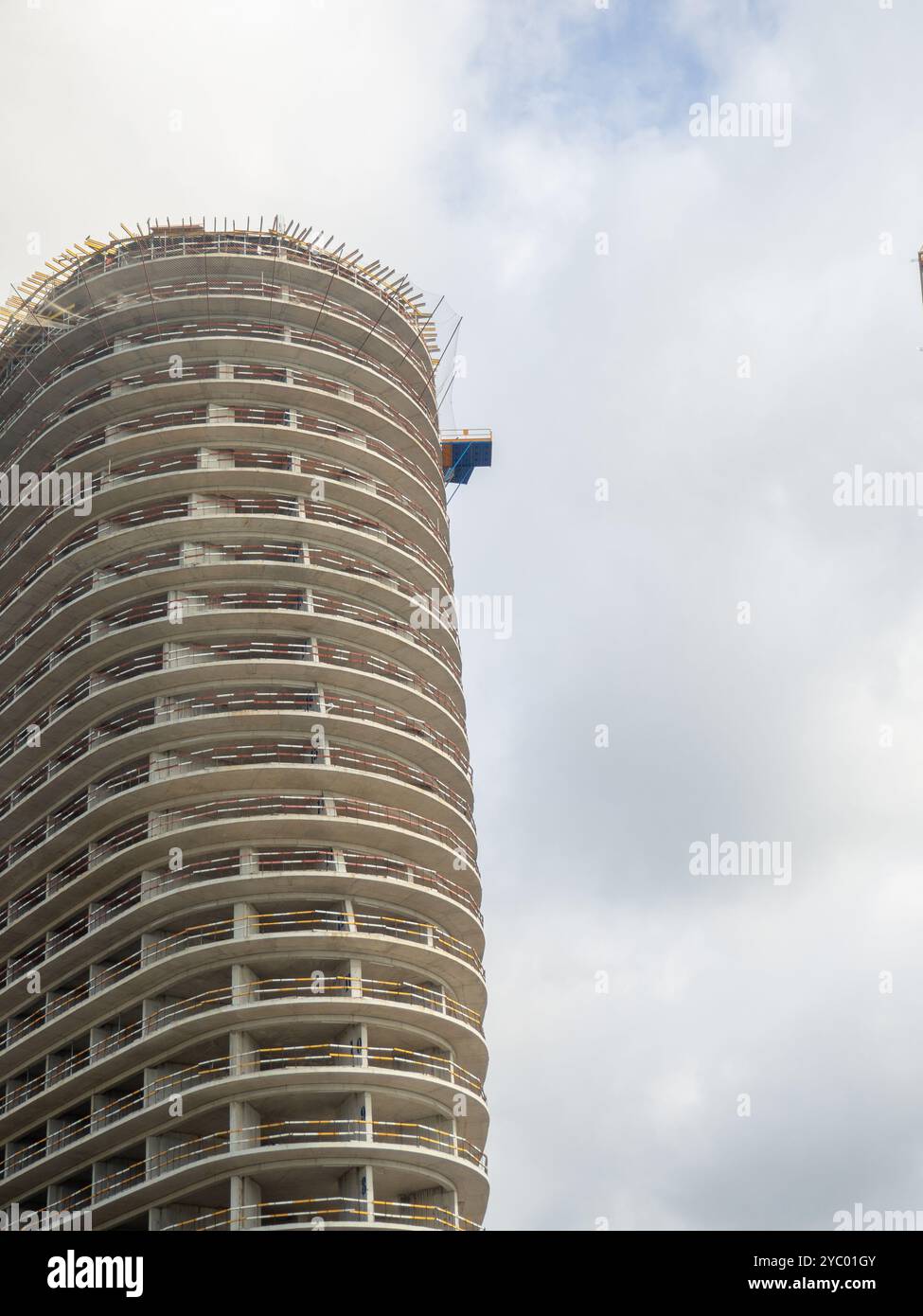 Costruzione di un alto edificio. Struttura in cemento. Attività edile. Casa rotonda. Gru sopra il cantiere Foto Stock