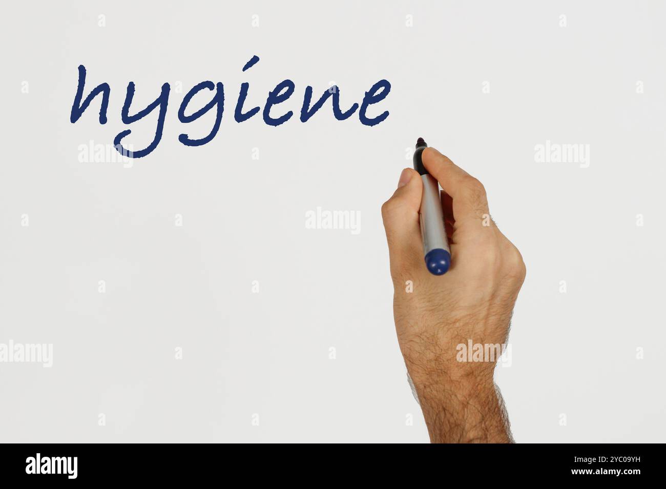 Un uomo scrive "igiene" sulla lavagna bianca con un pennarello blu. Spazio per il testo. Foto Stock