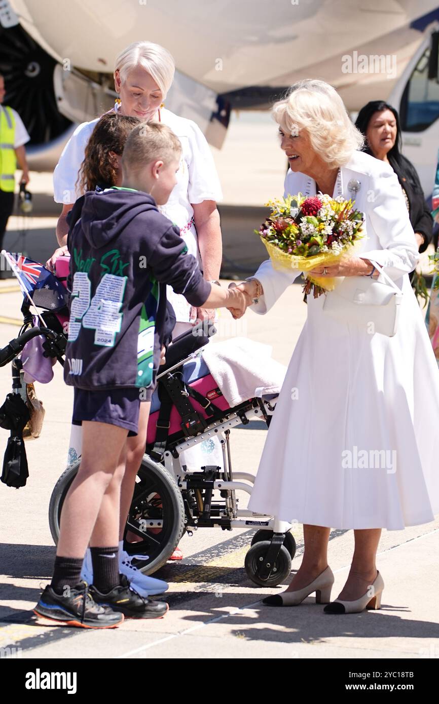 La regina Camilla parla con due scolari presentando fiori per la festa di benvenuto ufficiale australiana all'aeroporto di Canberra il secondo giorno della loro visita in Australia e Samoa. Data foto: Lunedì 21 ottobre 2024. Foto Stock